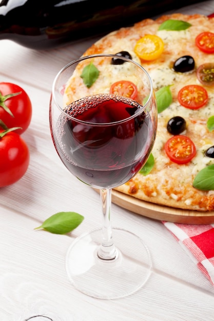 Copa de vino tinto y pizza italiana