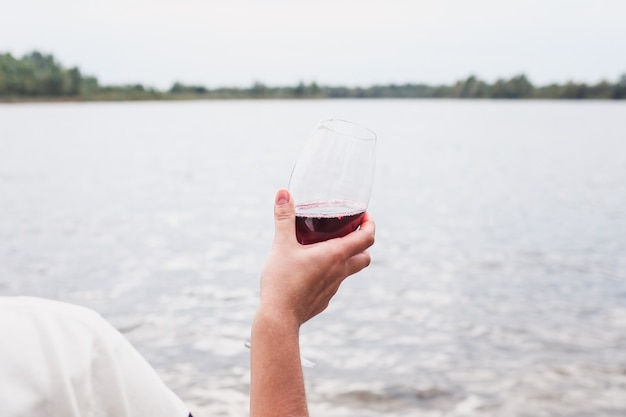 Copa de vino tinto seco en la mano