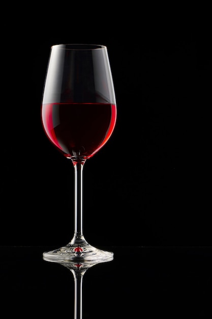 Foto una copa de vino tinto sobre una mesa brillante.