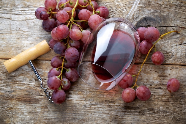 Copa de vino con uvas en mesa de madera