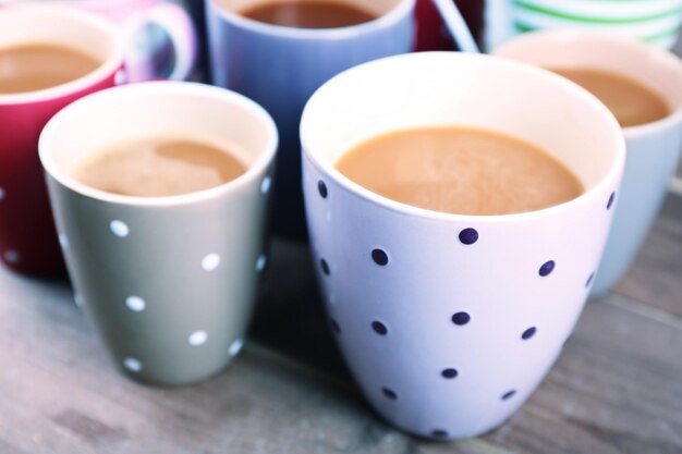 Copas de capuchino en una mesa de madera de cerca