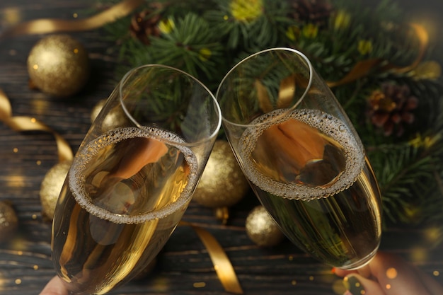 Copas de champán y accesorios de año nuevo en mesa de madera