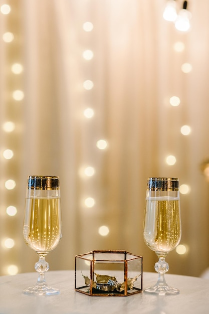 Copas de champán con anillos de boda en una caja de metal y hojas doradas secas Decoración de boda elegante de lujo para la ceremonia Compromiso de estilo otoñal