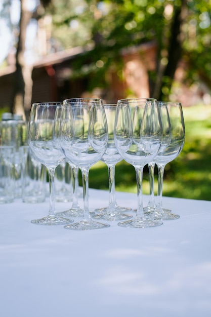 Las copas de champán de boda están sobre la mesa, sobre un mantel blanco en el jardín. boda.