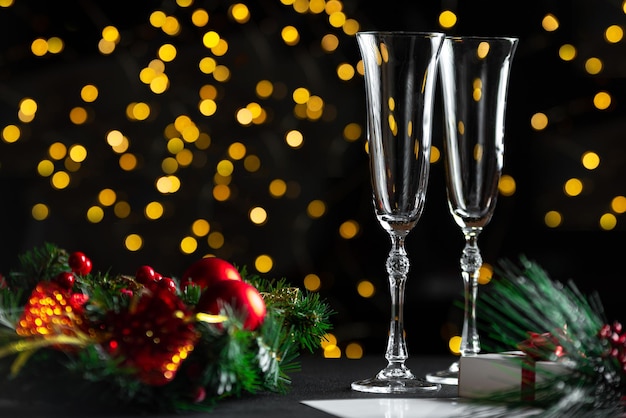 Copas de champán y bokek de garland en la mesa decorada de fondo con una corona de año nuevo