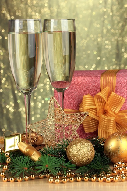 Copas de champán con caja de regalo sobre fondo brillante