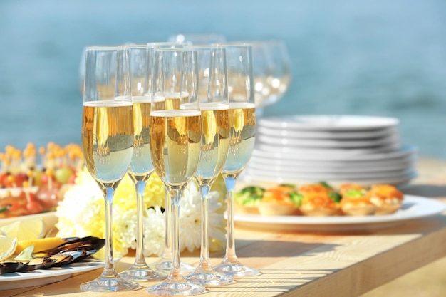 Copas de champán en la mesa servida para la fiesta de catering buffet al aire libre de cerca