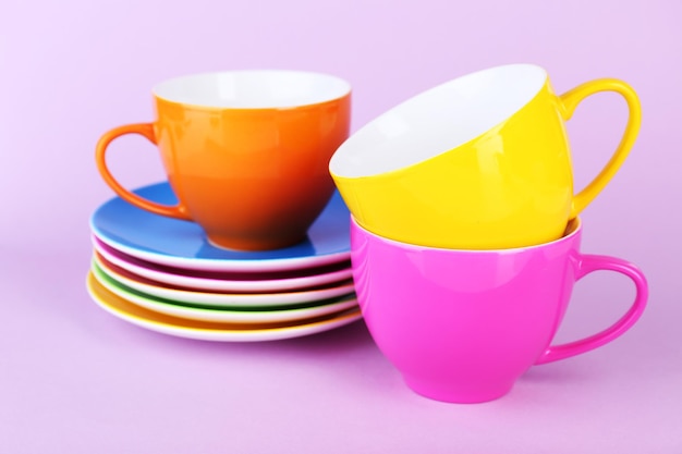 Foto copas y platillos coloridos sobre un fondo de color