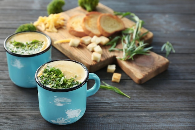 Copas con sopa de cheddar de brócoli en la mesa de la cocina