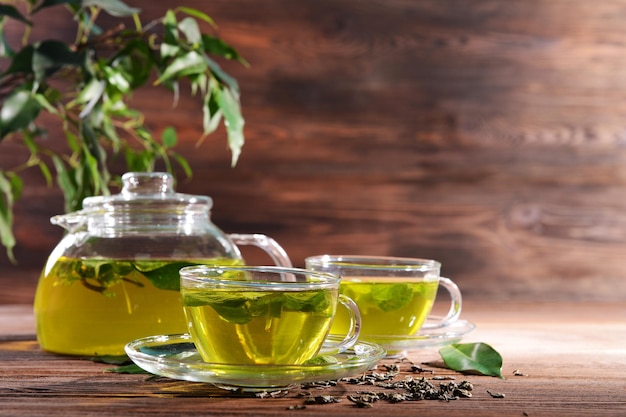 Copas de té verde en la mesa sobre un fondo de madera