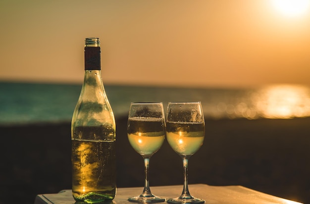 Copas de vino al atardecer en la playa. Enfoque selectivo.