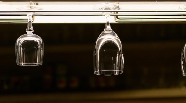 Copas de vino colgadas en el bar de licores por la noche