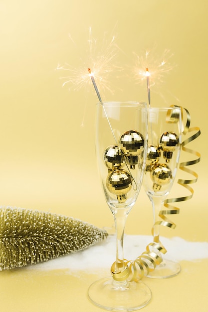 Foto copas de vino espumoso espumosos bolas de árbol de navidad fondo dorado de cinta