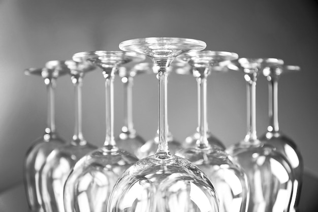 Copas de vino en una fila boca abajo sobre fondo gris claro