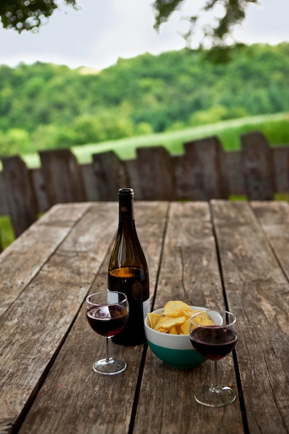 Copas de vino en una mesa de madera en el campo