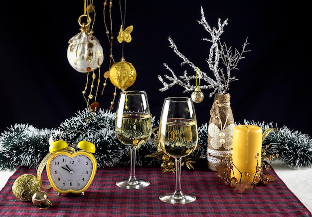 Las copas de vino Navidad juguetes ramas vela y reloj closeup