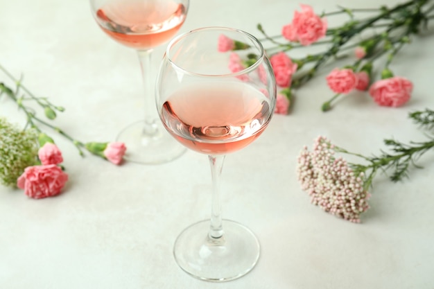 Copas de vino rosado y hermosas flores.