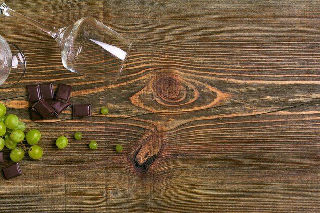 Copas de vino y uvas maduras aislado en una mesa de madera