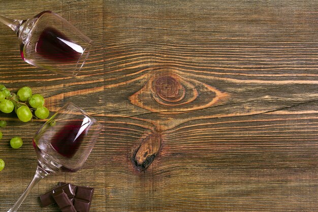 Copas de vino y uvas maduras aislado en una mesa de madera