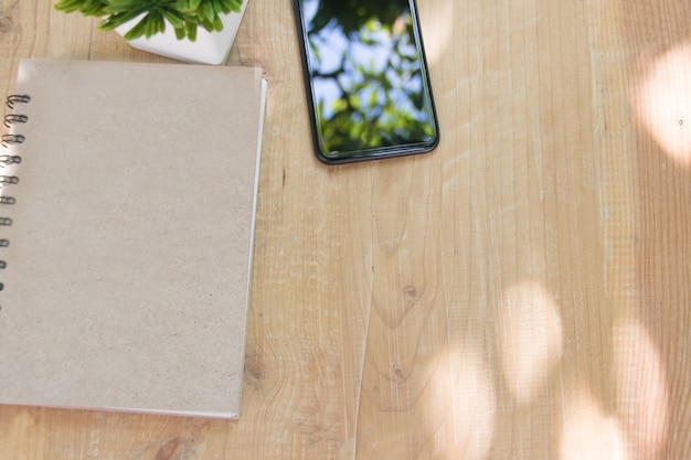 Copia espacio, libro y teléfono en la mesa de madera