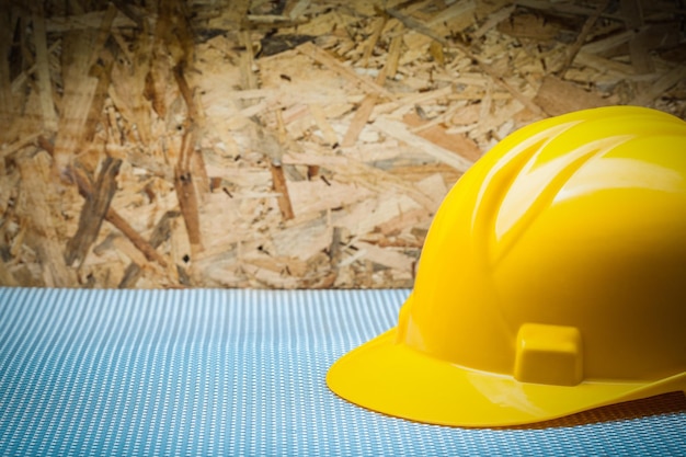 Copia espacio ver casco de construcción amarillo sobre fondo de madera contrachapada