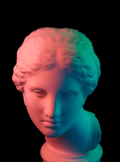 Copia de yeso de la antigua estatua de la cabeza de Venus de Milo para artistas aislado sobre fondo negro. Escultura de yeso de rostro de mujer. Tonos de varios colores.