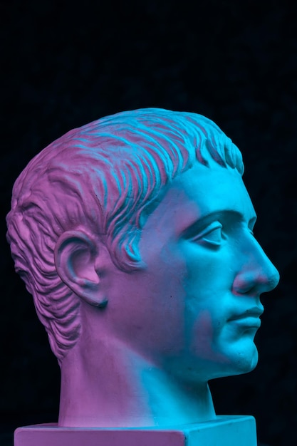 Copia de yeso púrpura azul de la antigua estatua de Germanicus Julius Caesar cabeza para artistas aislados sobre fondo negro Época renacentista Escultura de yeso de cara de hombre Plantilla para diseño de arte