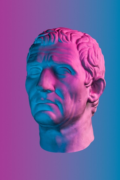 Copia de yeso púrpura azul de la antigua estatua de Guy Julius Caesar Octavian Augustus cabeza para artistas aislados sobre fondo de color Época renacentista Escultura de yeso de cara de hombre Plantilla para diseño de arte