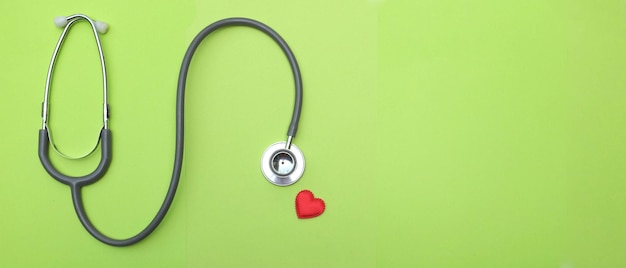 Foto copiar espacio corazón rojo estetoscopio blanco en la mesa verde del médicoconcepto de salud