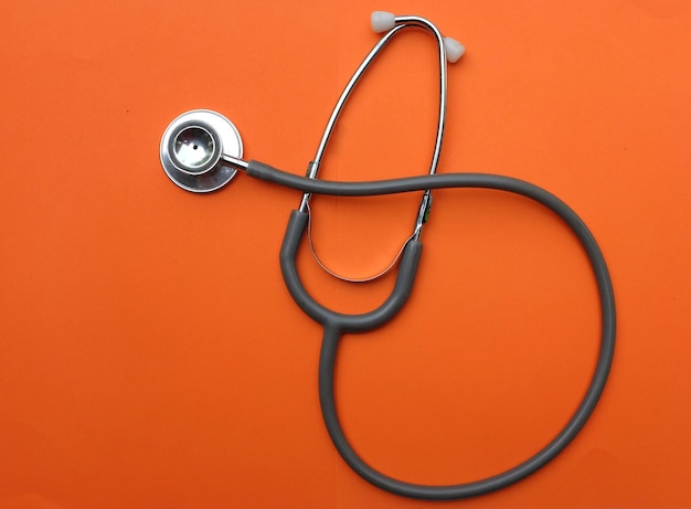 Copiar espaço e fechar estetoscópio médico em fundo laranja na secretária do médico