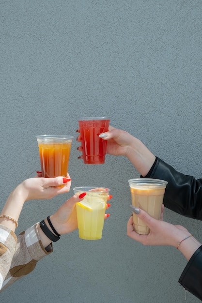 Copias de copas de bebidas de verano con hielo en las manos de las mujeres