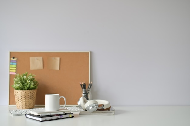 Copie el escritorio de oficina del espacio con la taza de café, el cuaderno y el material de oficina con el foco selectivo.