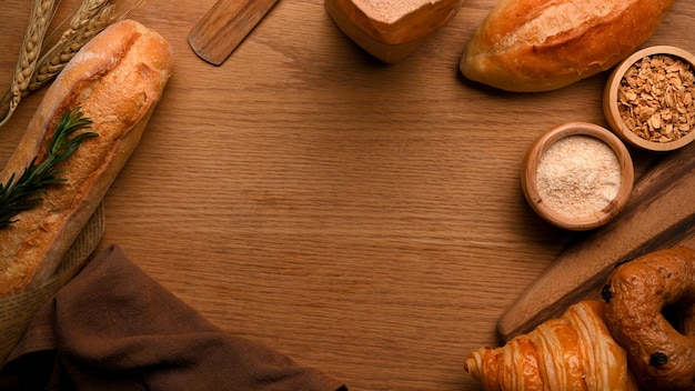 Copie el espacio sobre fondo de madera con panadería pan francés croissant bagel harina y granos