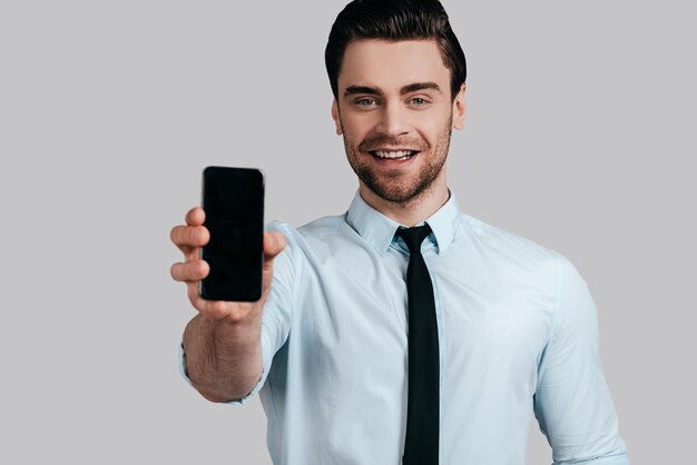 Copie el espacio en su teléfono móvil. Hombre de negocios, posar, contra, el, pared blanca