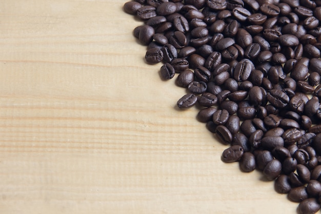 Copie el grano de café del espacio en el cierre de la tabla de madera, macro