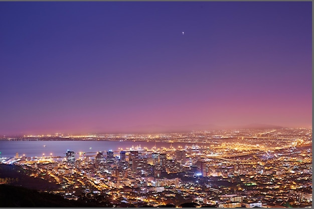 Copie o espaço com céu noturno crepuscular sobre a vista de uma cidade costeira vista de Signal Hill na Cidade do Cabo África do Sul Paisagem panorâmica cênica de luzes iluminando um horizonte urbano ao longo do mar