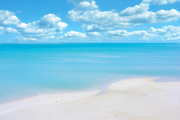 Copie o espaço na praia com um fundo de céu azul nublado acima do horizonte Água calma do oceano através do mar ao longo da costa Paisagem pacífica e tranquila para uma escapadela de verão relaxante e zen