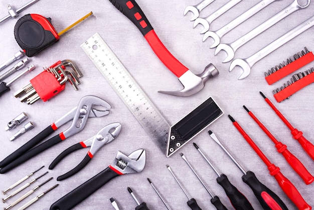 Foto coplet de herramientas de reparación en una pared gris. equipos para la construcción. kit de herramientas de reparación. vista desde arriba