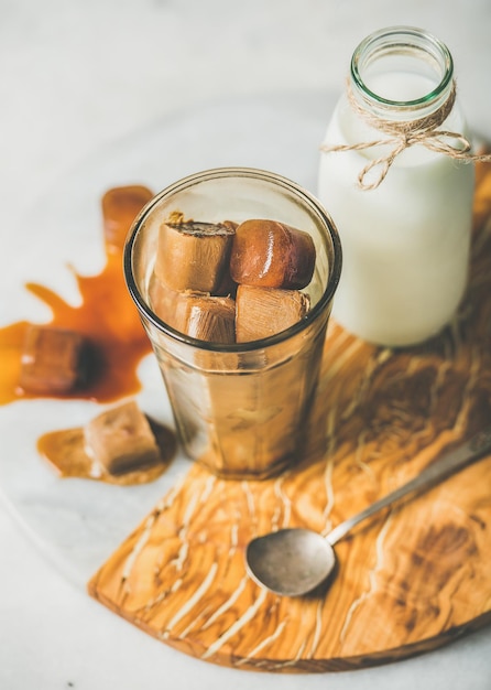 Copo com cubos de gelo de café congelado e leite a bordo