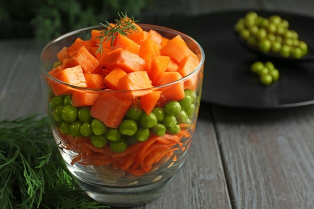 Copo com deliciosa salada de cenoura na mesa de madeira