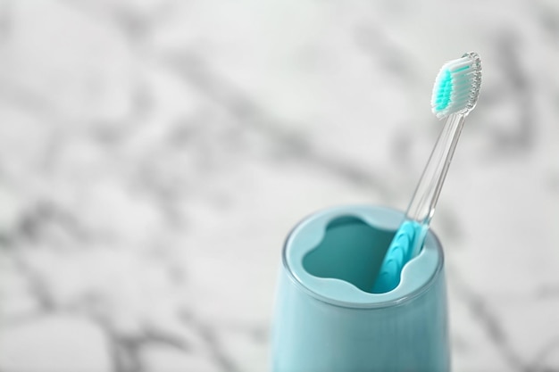 Copo com escova de dentes na mesa Atendimento odontológico