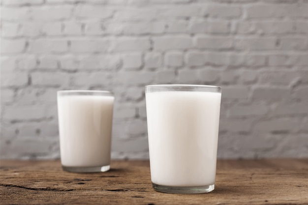 Foto copo com leite na mesa de madeira.