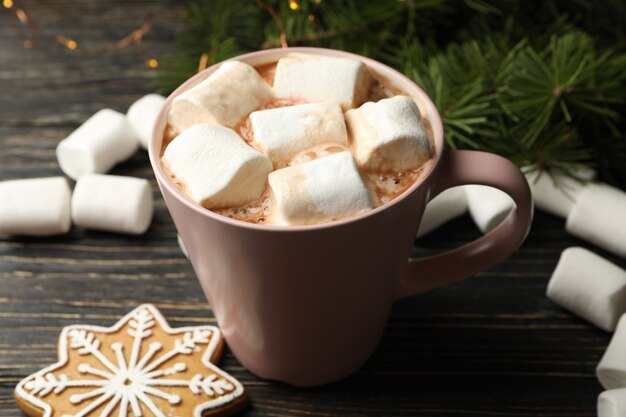 Copo com marshmallow na mesa de madeira com acessórios de natal