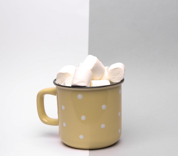 Copo com marshmallows em fundo cinza branco