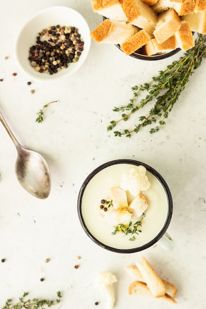 Copo com sopa de creme de couve-flor decore com couve-flor fresca, tomilho e pão. Comida de outono ou inverno. Jantar saudável.