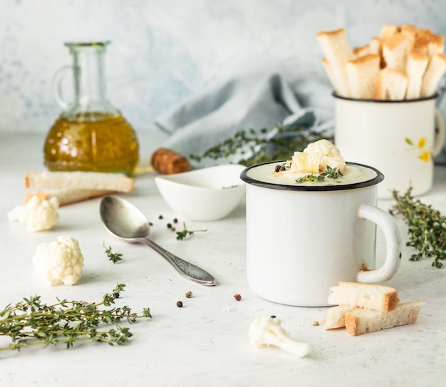 Copo com sopa de creme de couve-flor decore com couve-flor fresca, tomilho e pão. Comida de outono ou inverno. Jantar saudável.