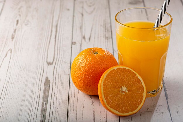 Copo com suco de laranja em cima da mesa.