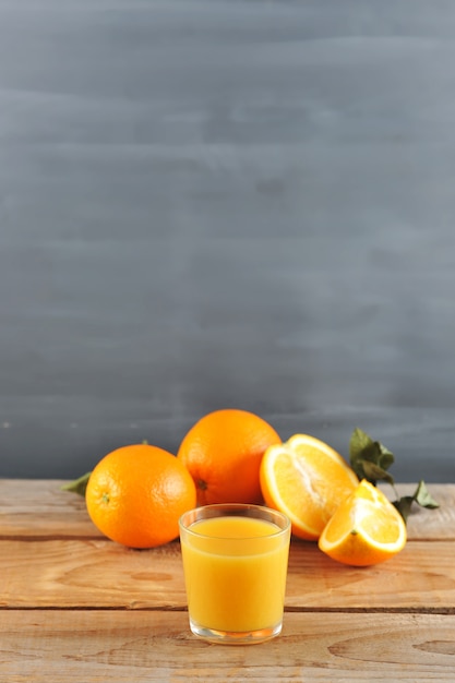 Copo com suco de laranja fresco nas laranjas inteiras