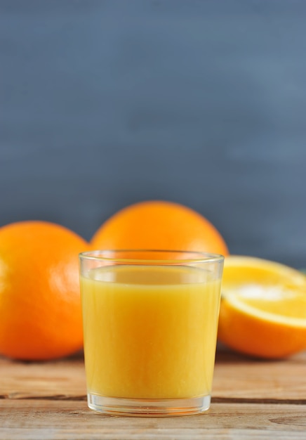 Copo com suco de laranja fresco nas laranjas inteiras