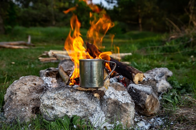 Copo de aço em fogo aberto na natureza Cozinhar no fogo Acampar no verão